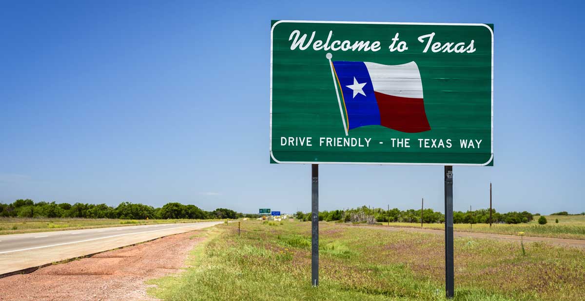 A welcome sign to Texas under the clear blue sky